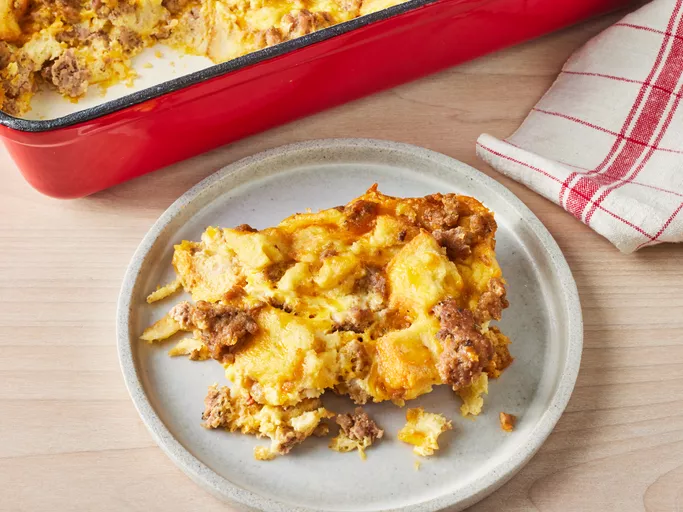 Freshly baked breakfast sausage casserole in a rectangular dish, featuring golden-brown top with visible pieces of sausage and melted cheese.