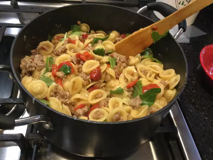 This One Pan Orecchiette Pasta is a simple, budget-friendly recipe perfect for students, busy professionals, or anyone looking for a quick and satisfying meal. With only a handful of ingredients and minimal cleanup, this dish packs flavor with spicy Italian sausage, fresh arugula, and a sprinkle of Parmigiano-Reggiano. Ready in just 40 minutes, it's a one-pan wonder you'll want to add to your weekly meal rotation! Ingredients for One Pan Orecchiette Pasta 2 tablespoons olive oil ½ onion, diced Salt, to taste 8 ounces spicy Italian sausages, casings removed 3 ½ cups low-sodium chicken broth, divided 1 ¼ cups orecchiette pasta (or more, to taste) ½ cup roughly chopped arugula (or more, to taste) ¼ cup finely grated Parmigiano-Reggiano cheese (or more, to taste) Instructions: How to Make One Pan Orecchiette Pasta Step 1: Sauté the Onion and Sausage In a large, deep skillet, heat 2 tablespoons of olive oil over medium heat. Add the diced onion along with a pinch of salt and sauté until the onion softens and becomes translucent, about 5 minutes. Add the spicy Italian sausage and cook, stirring occasionally, until browned and cooked through (about 5 to 7 minutes). Step 2: Add Chicken Broth and Orecchiette Pour 1½ cups of chicken broth into the sausage mixture. Use a wooden spoon to scrape up any browned bits from the bottom of the skillet, bringing extra flavor to the dish. Bring the broth to a boil. Stir in the orecchiette pasta, ensuring it is fully coated in the broth. As the pasta absorbs the broth, continue adding the remaining chicken broth in increments, stirring regularly. Cook for about 15 minutes, or until the pasta is tender and most of the broth is absorbed. Step 3: Stir in Arugula and Serve Once the pasta is fully cooked, stir in ½ cup of chopped arugula, allowing it to wilt in the hot pasta mixture. Ladle the orecchiette into bowls and generously sprinkle each serving with finely grated Parmigiano-Reggiano. Serve hot and enjoy! Why You’ll Love This One Pan Orecchiette Pasta Quick and easy: Perfect for busy weeknights or students looking for a fast, hearty meal. Minimal cleanup: This entire dish is made in just one pan, making it convenient and mess-free. Delicious and flavorful: The combination of spicy sausage, fresh arugula, and savory cheese creates a satisfying dish that tastes like you spent hours in the kitchen! Tips for Success Customize your greens: If you’re not a fan of arugula, you can substitute with spinach, kale, or your favorite leafy green. Add more broth as needed: If the pasta looks too dry, feel free to add a bit more broth to achieve your desired consistency. Make it vegetarian: For a vegetarian version, substitute the sausage with a plant-based option or add more vegetables like mushrooms or bell peppers. Nutrition Information (per serving) Calories: 662 Total Fat: 39g Saturated Fat: 12g Cholesterol: 60mg Sodium: 1360mg Carbohydrates: 46g Dietary Fiber: 3g Protein: 31g This simple and delicious One Pan Orecchiette Pasta recipe is sure to become a favorite in your kitchen! It's quick, budget-friendly, and packed with flavor, making it perfect for weeknight dinners. Enjoy!