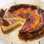 Richly caramelized 'Burnt' Basque Cheesecake on a serving plate, showcasing its iconic dark top and creamy interior.