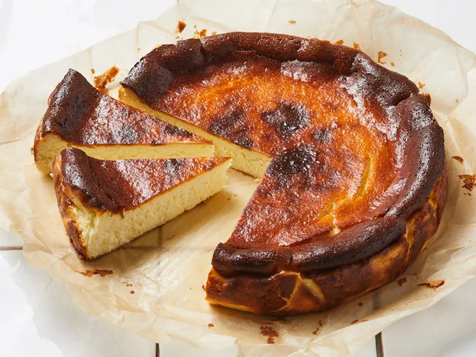 Richly caramelized 'Burnt' Basque Cheesecake on a serving plate, showcasing its iconic dark top and creamy interior.