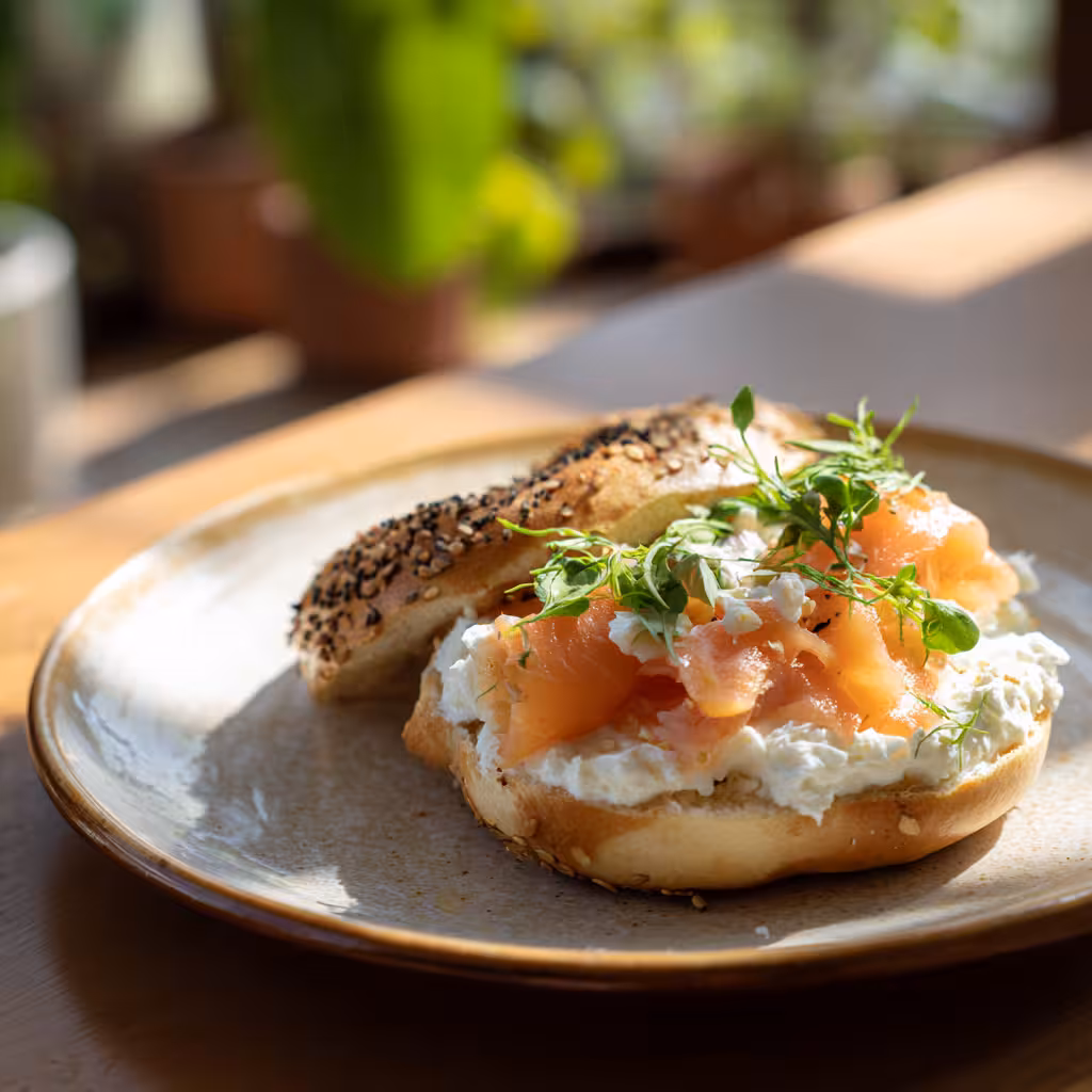 Homemade egg bagels stacked on a ceramic plate in natural light