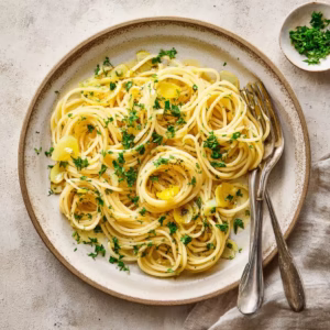 Spaghetti aglio e olio on ceramic plate with garlic and parsley