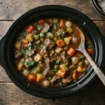 Slow cooker beef stew with tender beef, carrots and potatoes in a rich gravy, topped with fresh parsley